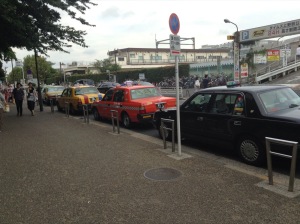 Parked taxis; black, red, yellow, in a row