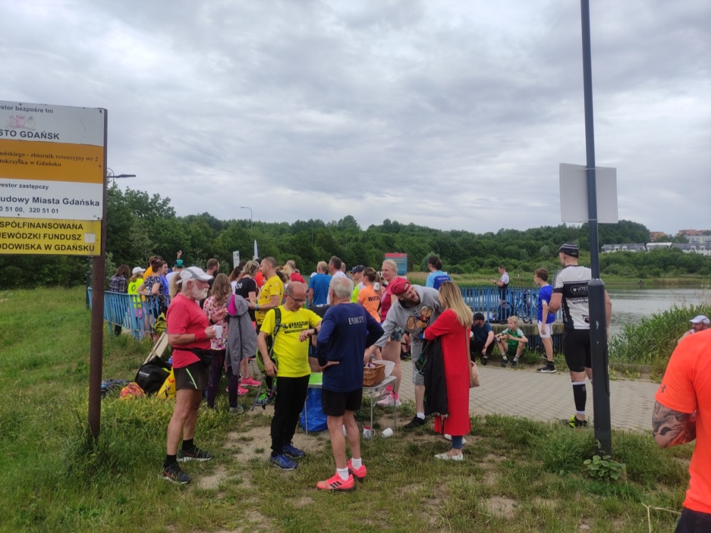 A crowd of runners by the lake after finishing the event.