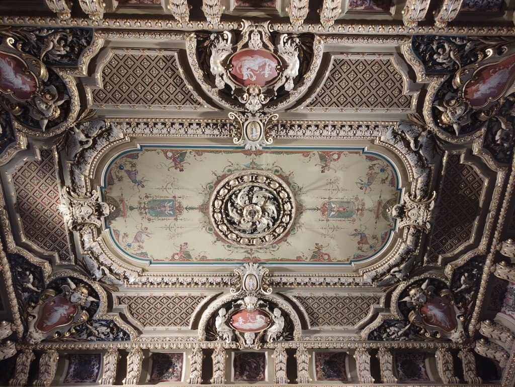 Ornate decoration in the ceiling. Not lavishly coloured, but there are very detailed carvings.